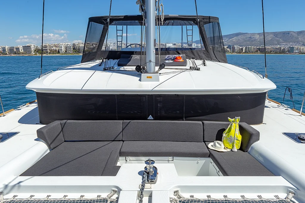 Front deck of a sailing catamaran with sun cushions, anchored in Greece