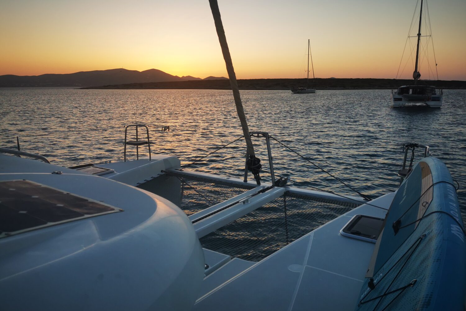 Sunset over the Ionian sea from the bow of a catamaran