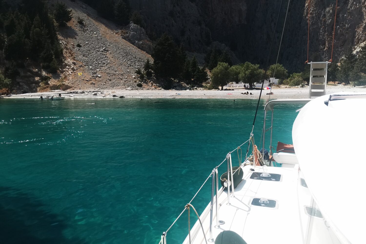 Catamaran anchored in a clear green bay in the Ionian